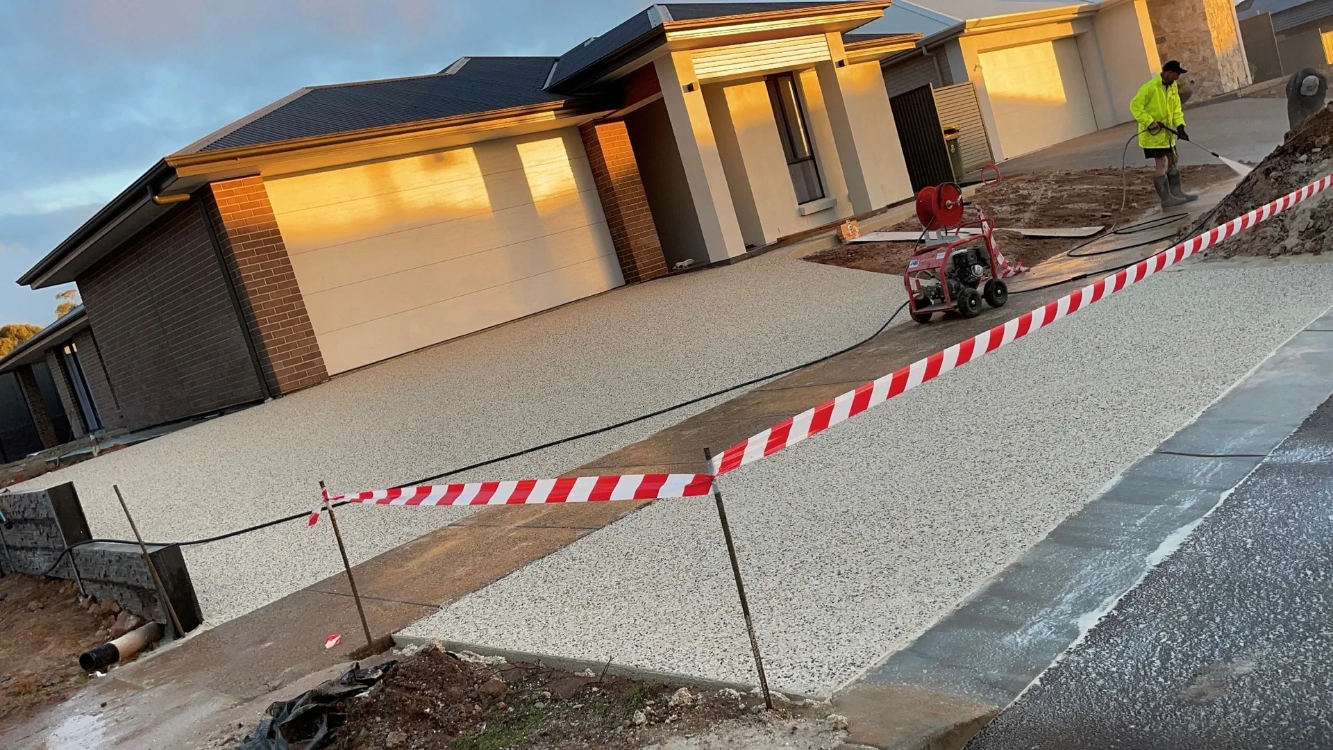Exposed aggregate concrete driveway on a new Adelaide home, being washed off to expose the stone